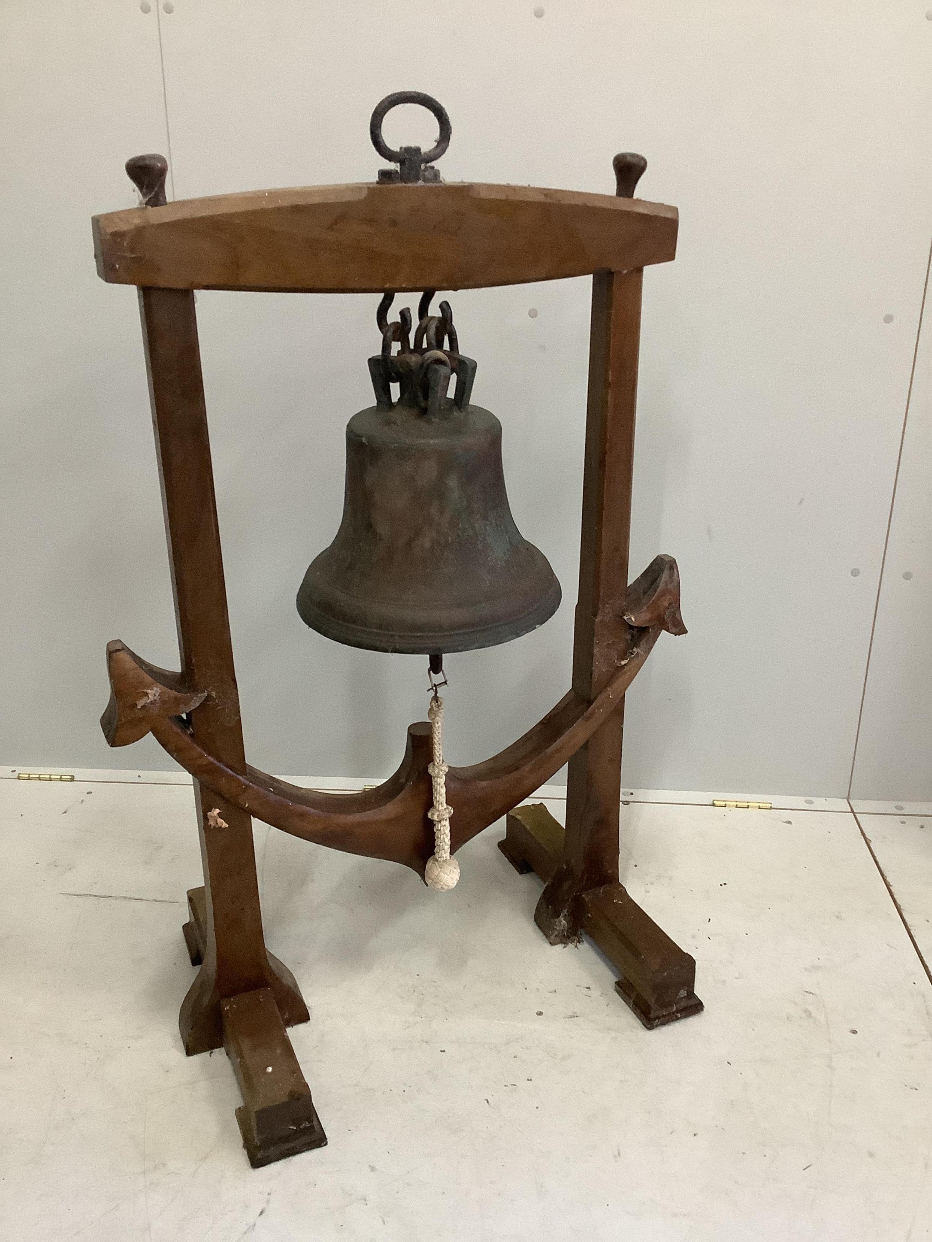 A bronze ship's bell, raised in an anchor shaped wooden frame, height 118cm. Condition